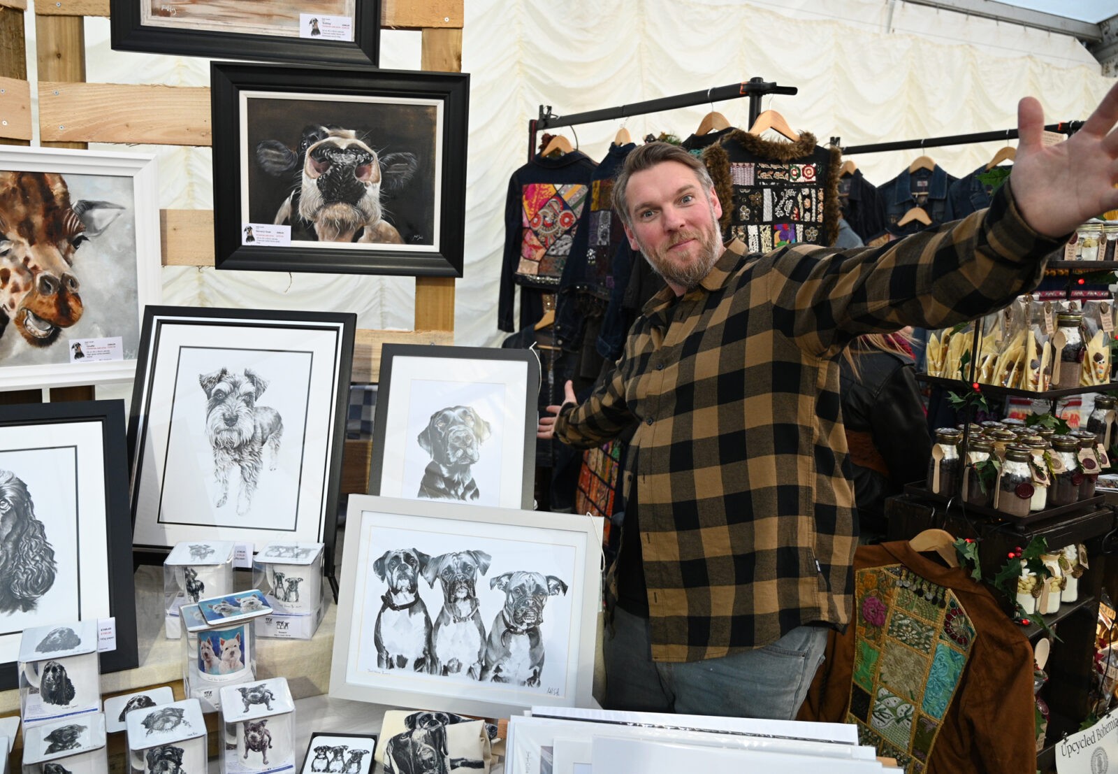 A man showing off some artwork of animals