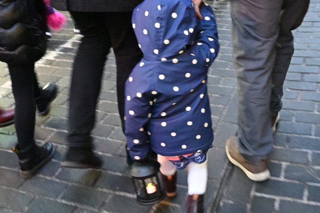 A young child carrying a lantern