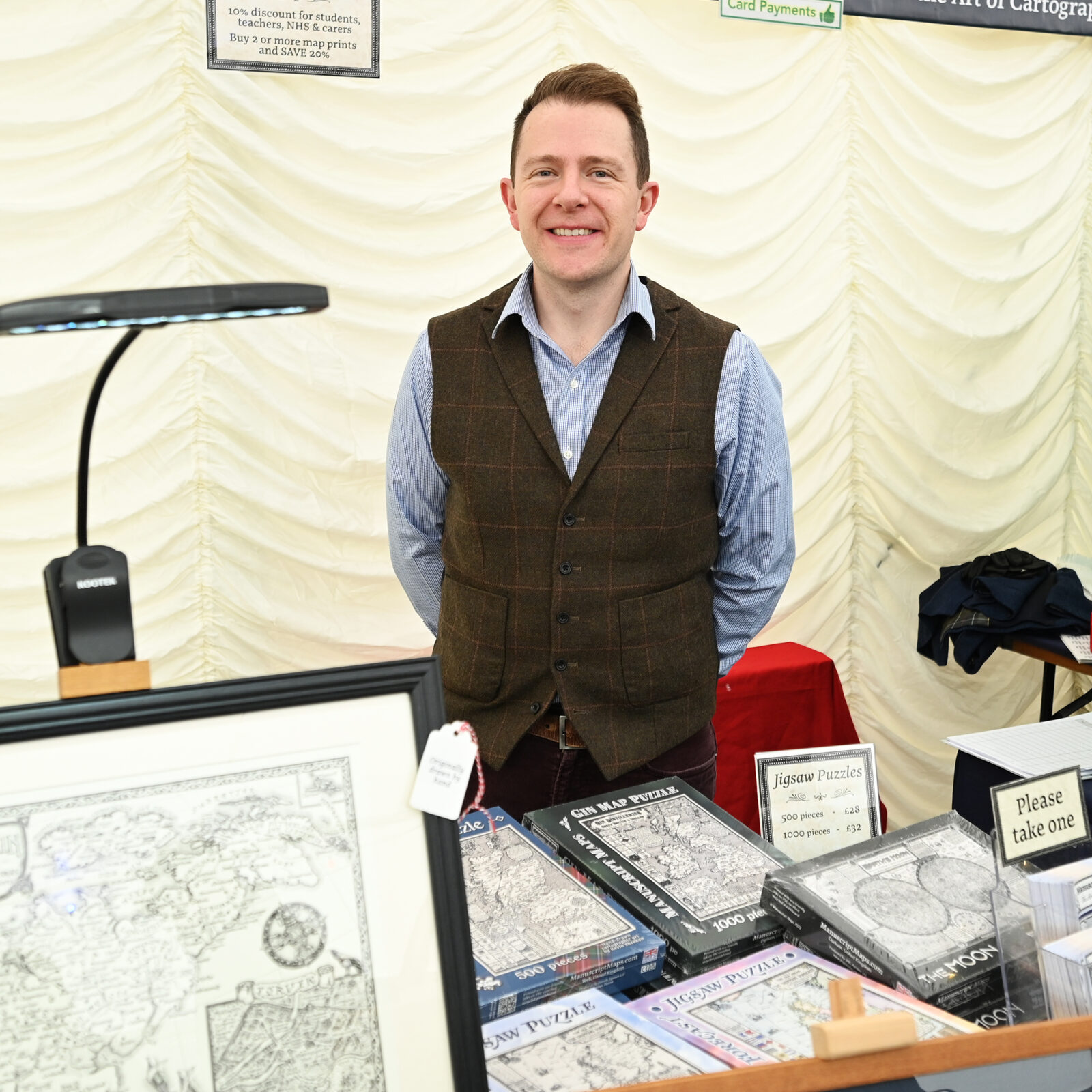 A man selling Manuscript Maps artwork and puzzles
