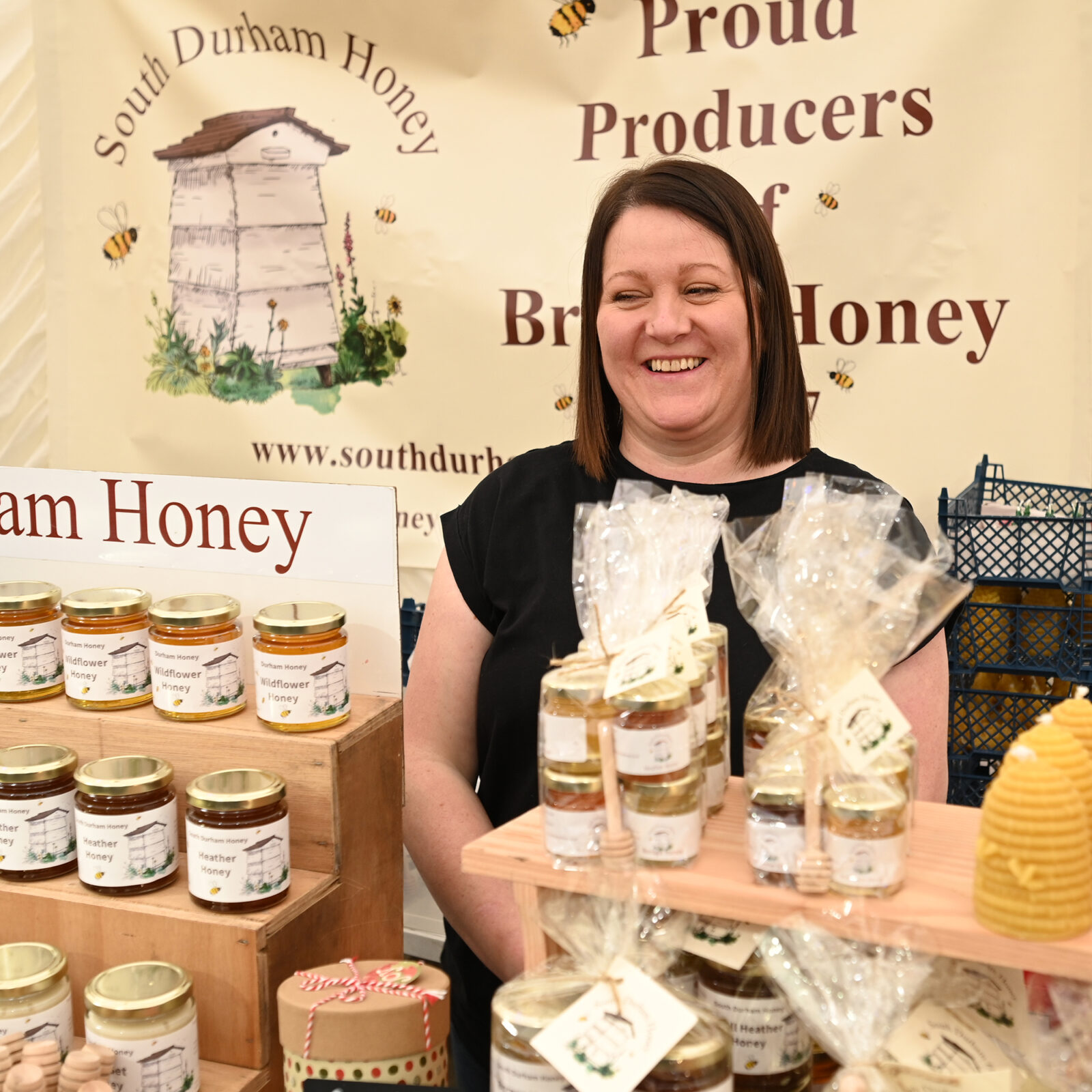 A smiling lady selling honey