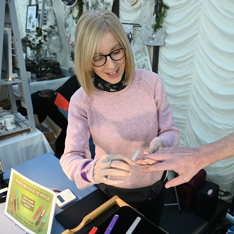 A woman filing someone's nails