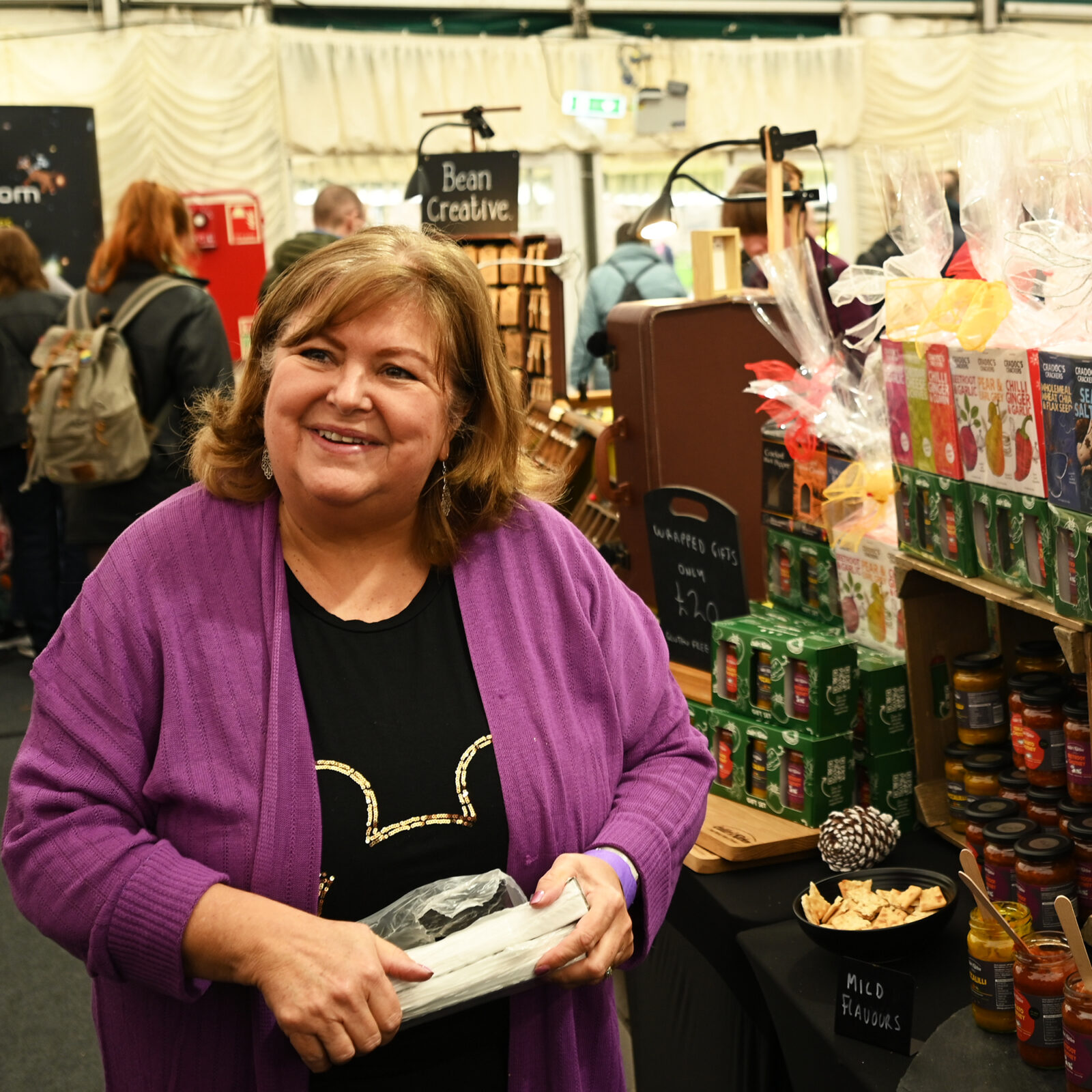 A smiling woman selling condiments