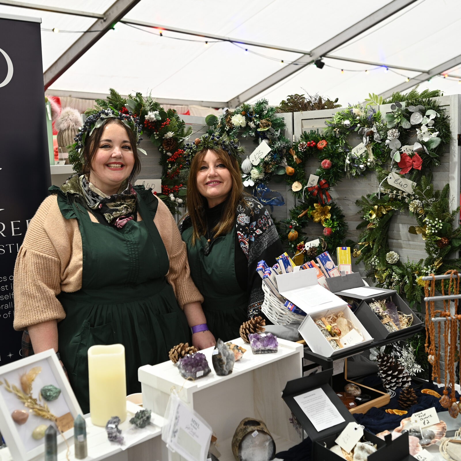 Two ladies selling Christmas door wreaths