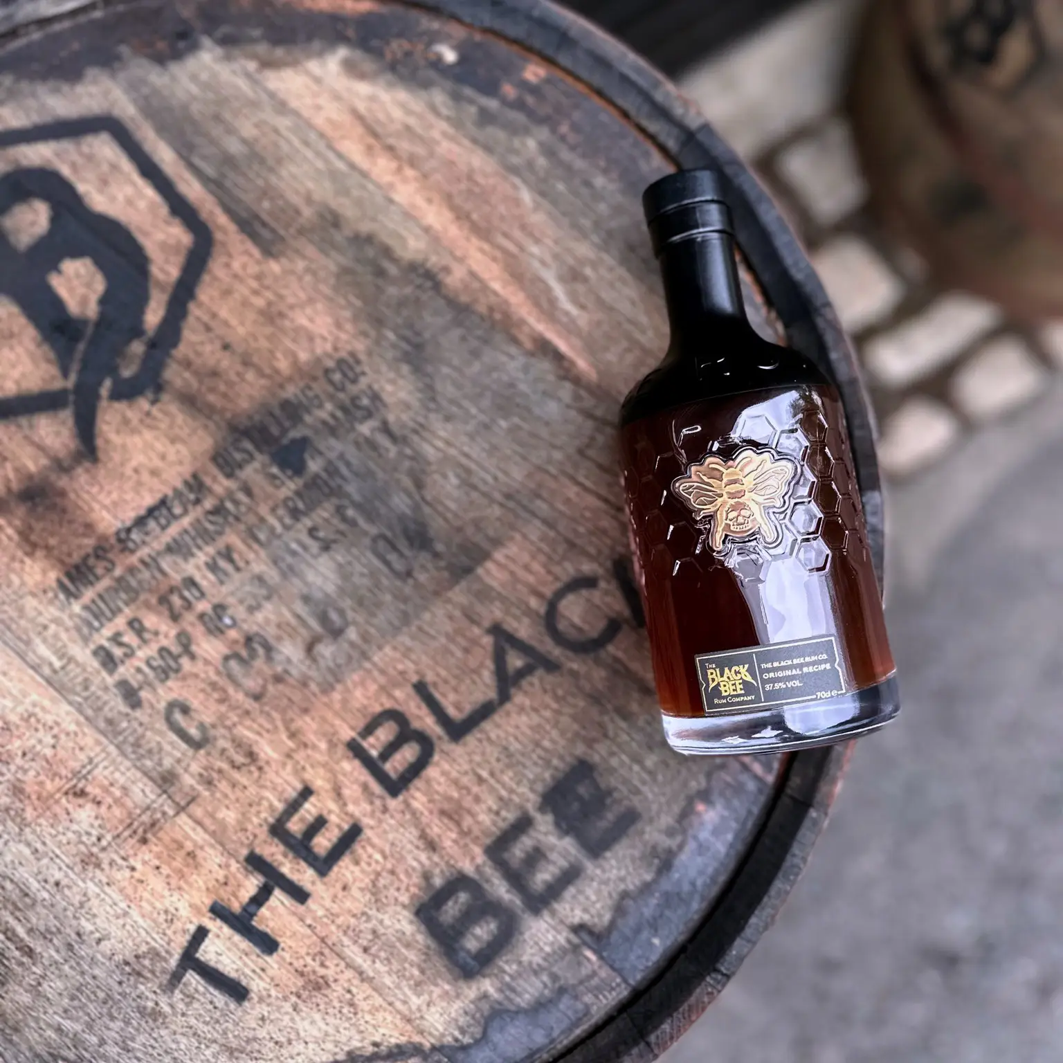 A bottle of rum on a wooden cask
